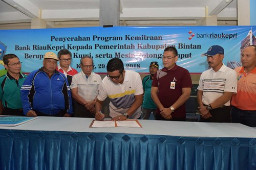 Bupati Kabupaten Bintan Apri Sujadi menandatangani berita acara serah terima CSR Bank Riau Kepri yang disaksikan langsung oleh Direktur Utama Bank Riau Kepri DR. Irvandi Gustari beserta Komut HR. Mambang Mit 