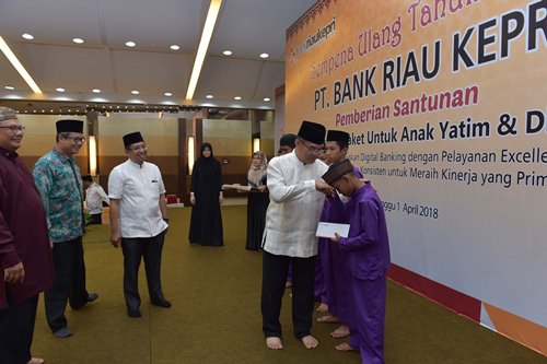 Direktur Utama Bank Riau Kepri DR. Irvandi Gustari menyerahkan langsung santunan secara simbolis kepada salah satu anak yatim dari 1115 orang Anak Yatim 