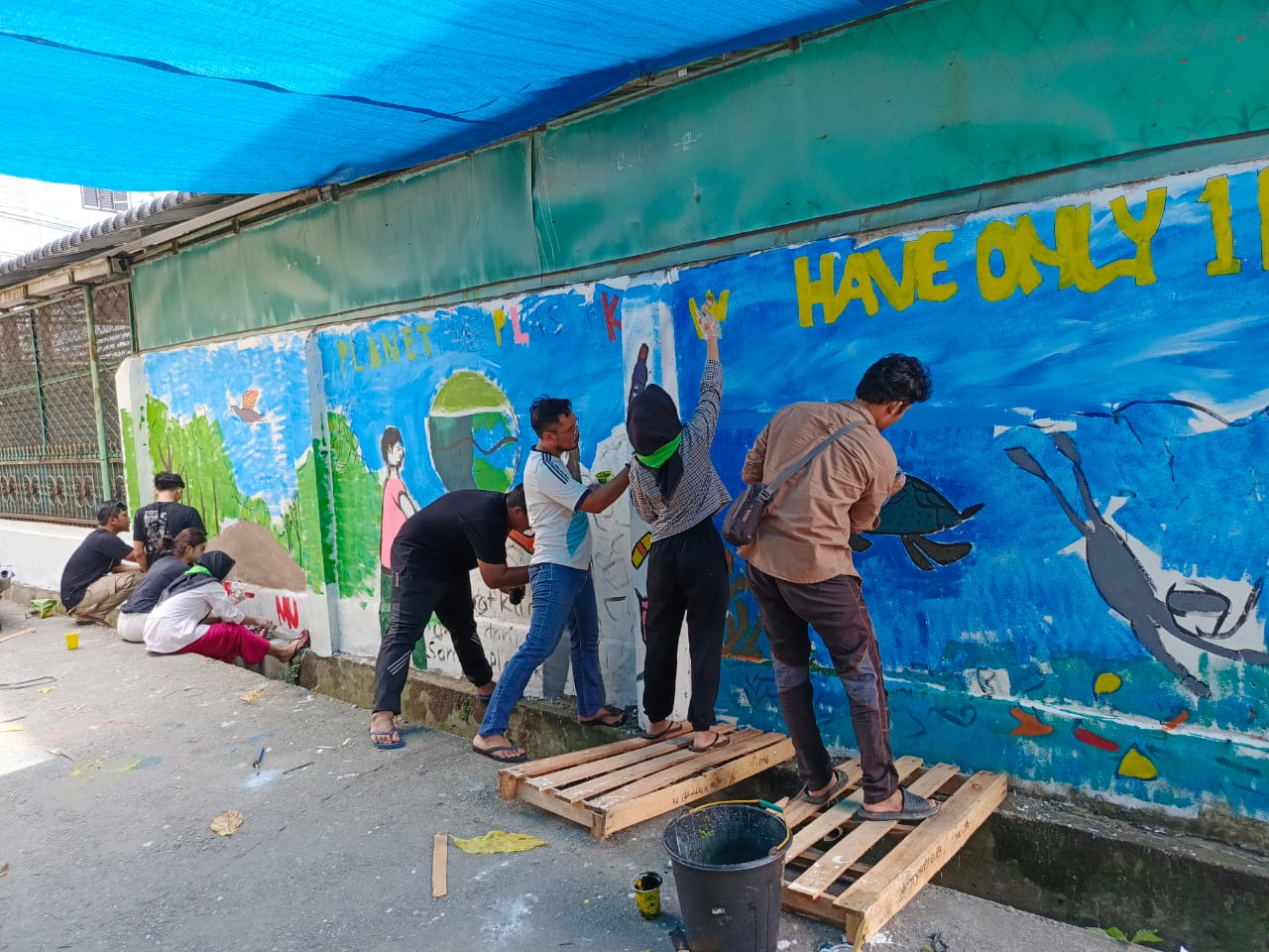 Melukis Beragam Pesan Hari Bumi di Tembok Pemukiman Sekitar WALHI Riau