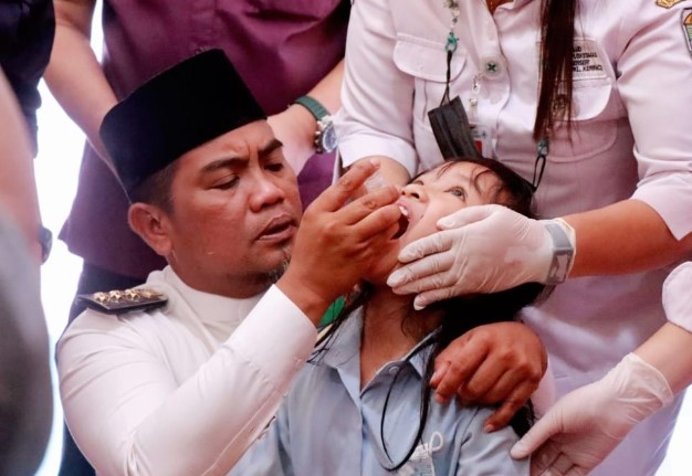 Bupati Pelalawan H. Zukri SE ketika memberikan Vaksin kepada salah satu anak (Foto Dok MC)